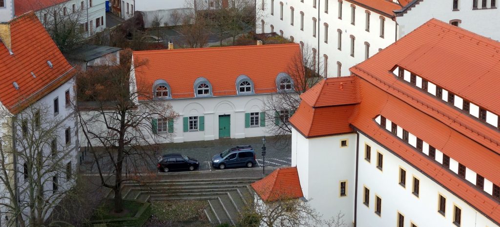 Blick vom Schlossturm auf das Haus SchlossGarten mit Schloss Hartenfels